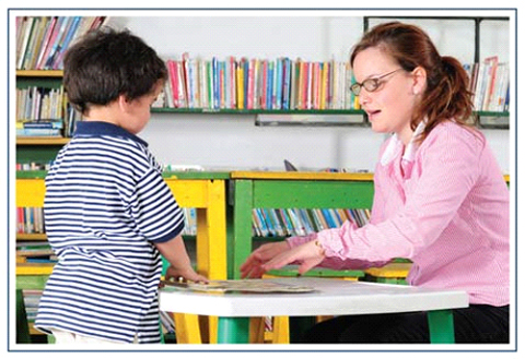 A child and an adult working with learning materials at a table